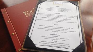 A menu with various food and drink options, including a selection of desserts and wine.