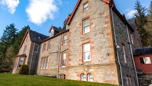 A large stone building with multiple windows and a red roof. - The Inch Hotel (Fort Augustus)