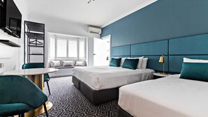 A modern hotel room with a large bed, a desk, and a seating area with a view of the outdoors. - Avoca Randwick by Sydney Lodges (Randwick)