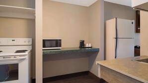 A compact kitchen with a microwave, a stove, and a refrigerator.