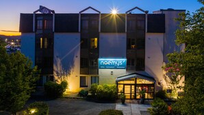 A hotel with a modern design, featuring a prominent sign for 'noemys' hotel, restaurant, and seminars. The building has multiple floors with balconies and large windows. - Logis Hôtel Noemys Brive - Restaurant Le Teinchurier (Brive-la-Gaillarde)