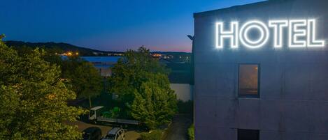 A hotel building with a 'HOTEL' sign illuminated in white lights.