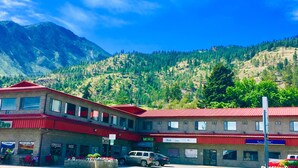 Un hotel con techo rojo, un cartel del Centro WorkBC, y montañas al fondo.