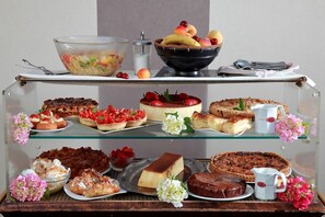 A dessert display with various cakes and pastries on shelves. - Le Luth (Mirecourt)