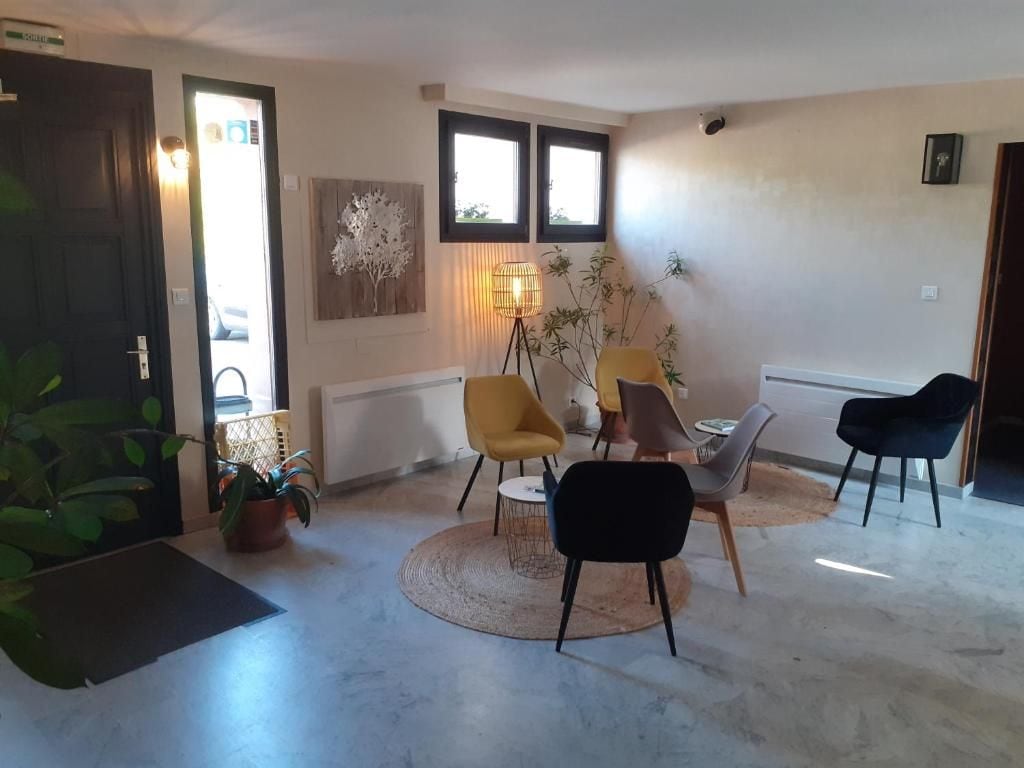 Um quarto com porta, janela, luminária e cadeira.