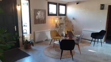 Um quarto com porta, janela, luminária e cadeira.
