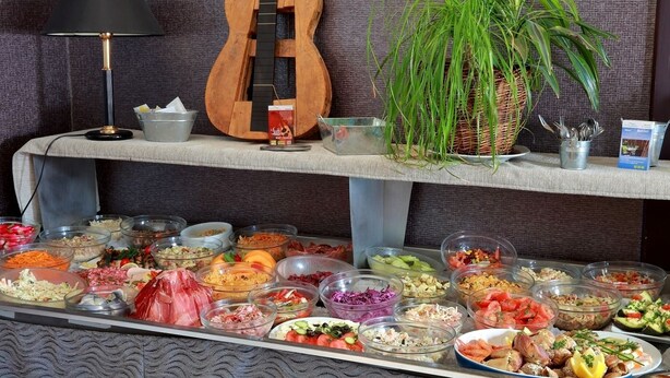 A buffet table with various food items and a guitar on a shelf. - Le Luth (Mirecourt)