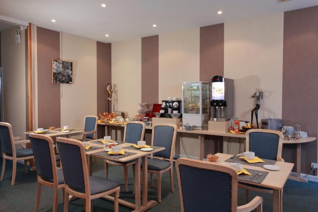 A dining area with tables and chairs, a coffee machine, and a refrigerator.