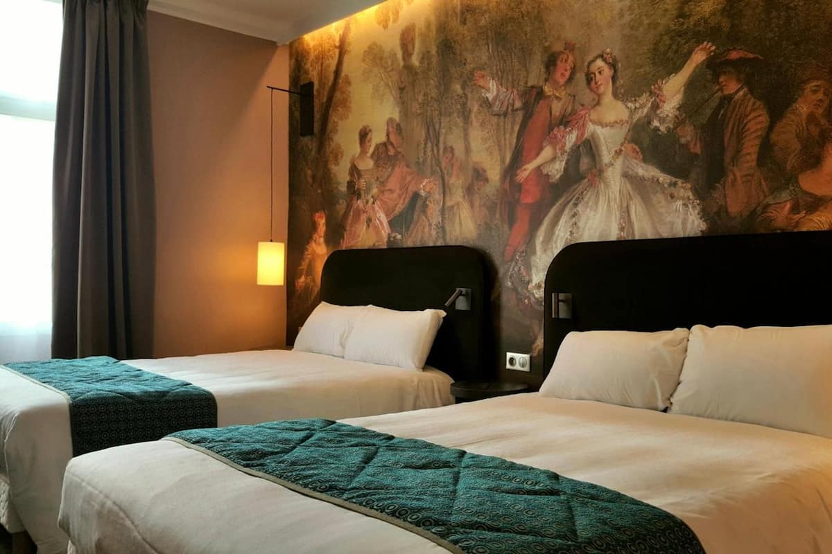 A hotel room with two beds, a large mural on the wall, and a window with curtains.
