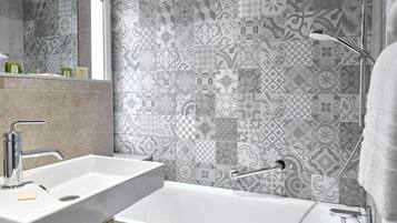 A bathroom with two sinks, a bathtub, and a shower.