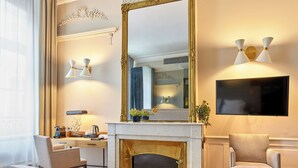 A hotel room with a bed, a desk, a fireplace, a chair, and a large mirror. - Hotel De Guise (Nancy)