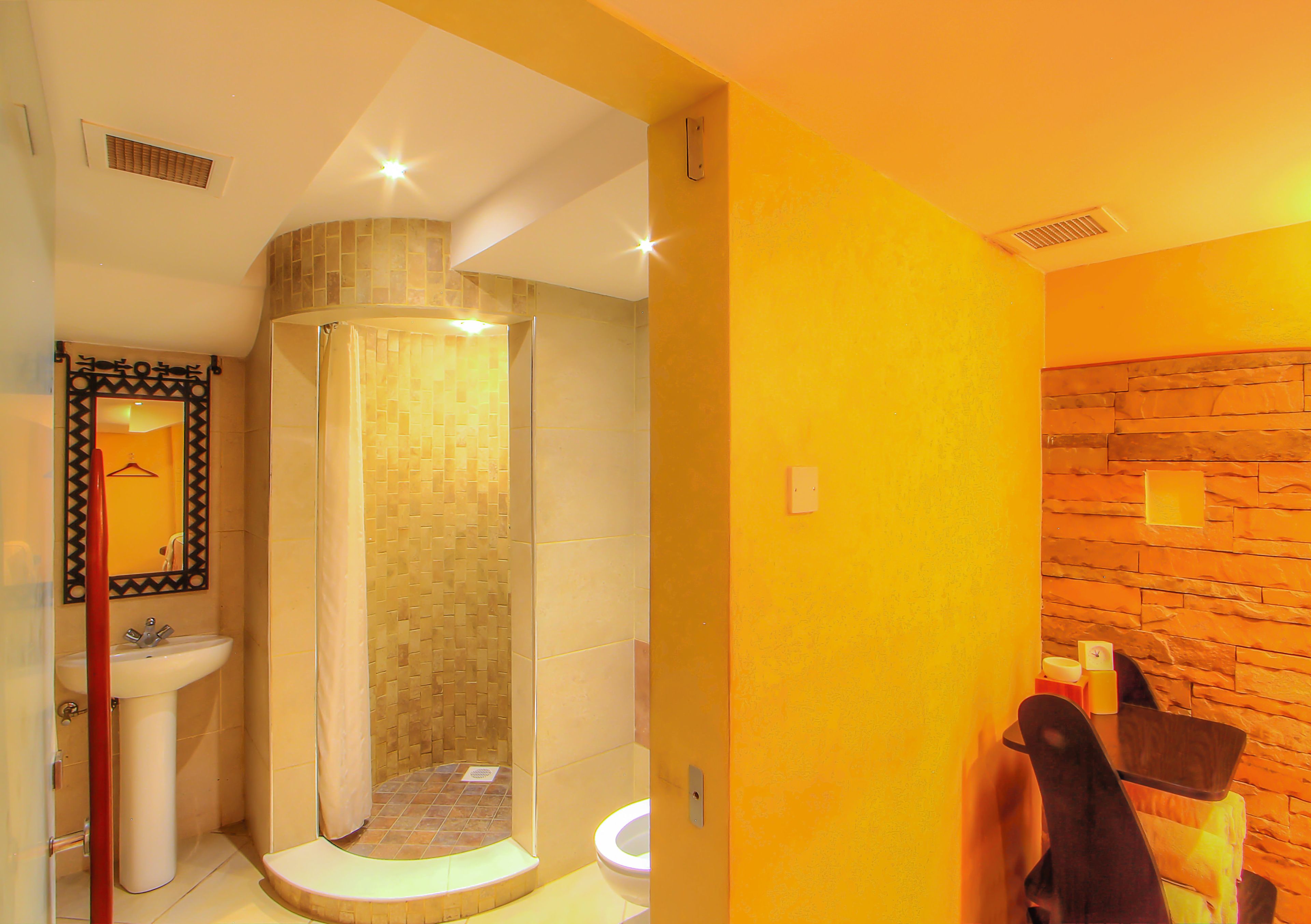 Un baño con ducha, lavamanos e inodoro.