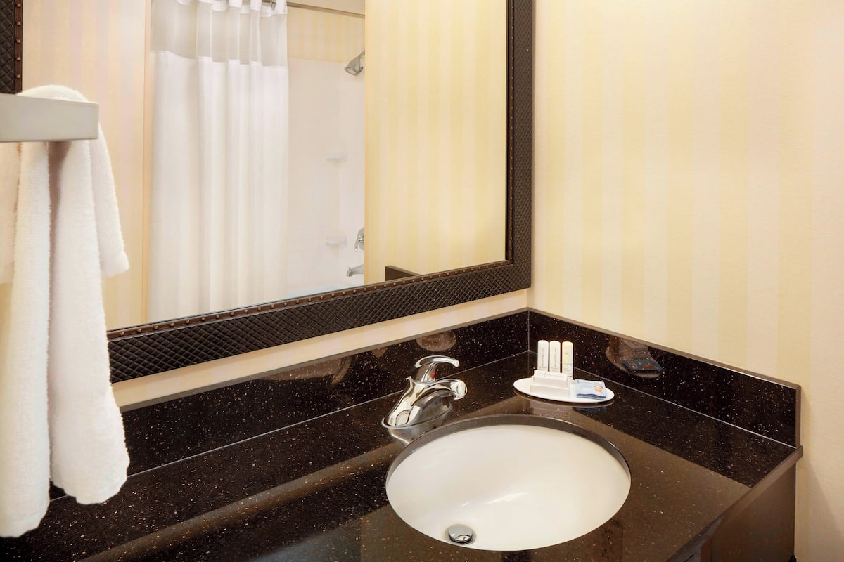Une salle de bain avec un lavabo rond, un miroir et un porte-serviettes.