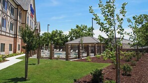 A building with a swimming pool, covered patio, and landscaped garden. - Fairfield Inn & Suites by Marriott Selma Kingsburg (Kingsburg)