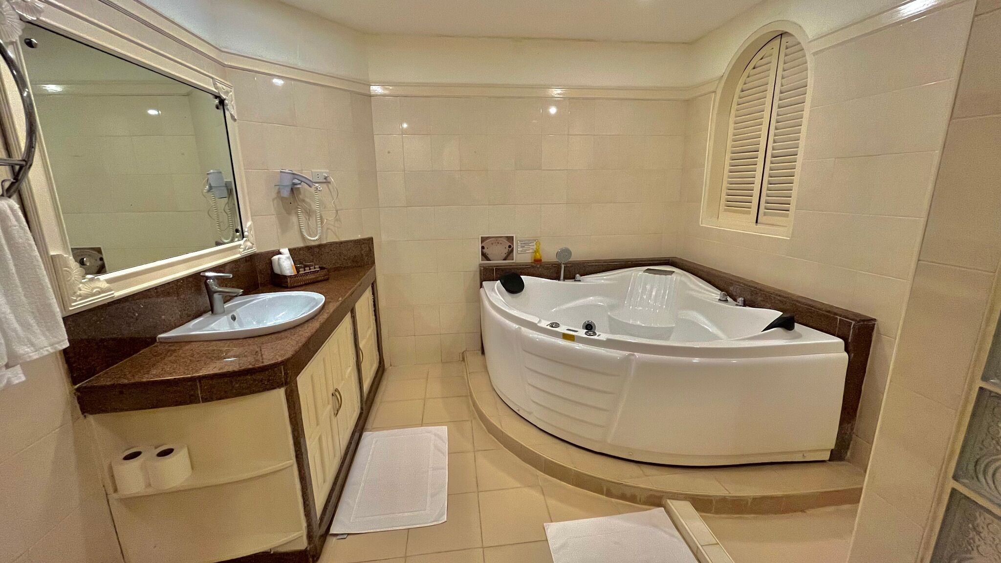 Un baño moderno con una bañera grande, un lavabo y un mueble de tocador con espejo.