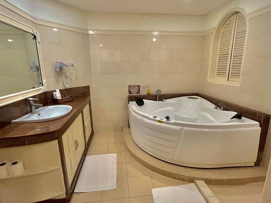 Un baño moderno con una bañera grande, un lavabo y un mueble de tocador con espejo.