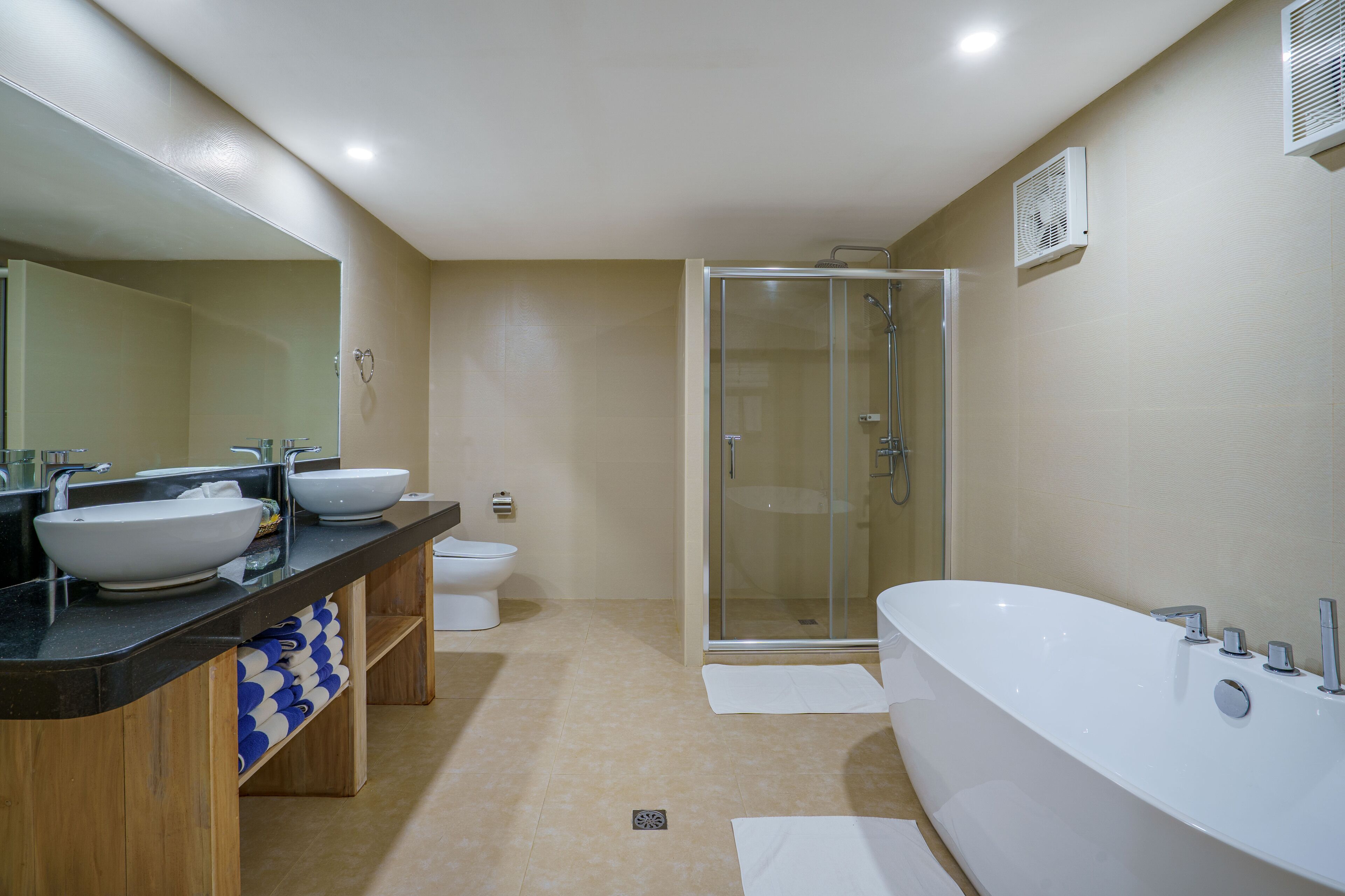 A modern bathroom with a large bathtub, a glass-enclosed shower, and a double sink vanity.