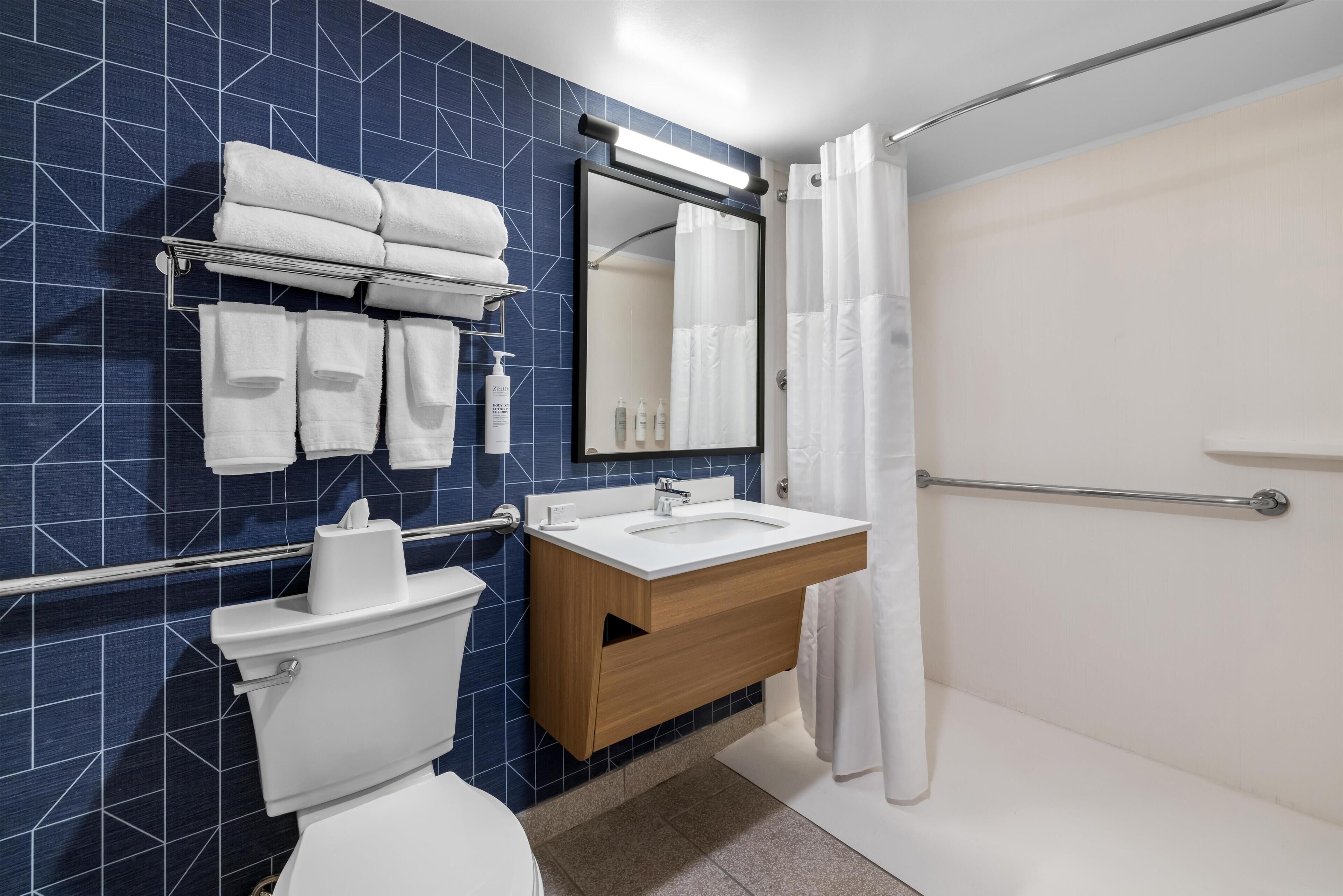 A modern bathroom with a toilet, sink, and shower.