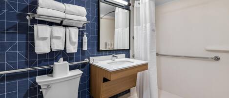 A modern bathroom with a toilet, sink, and shower.