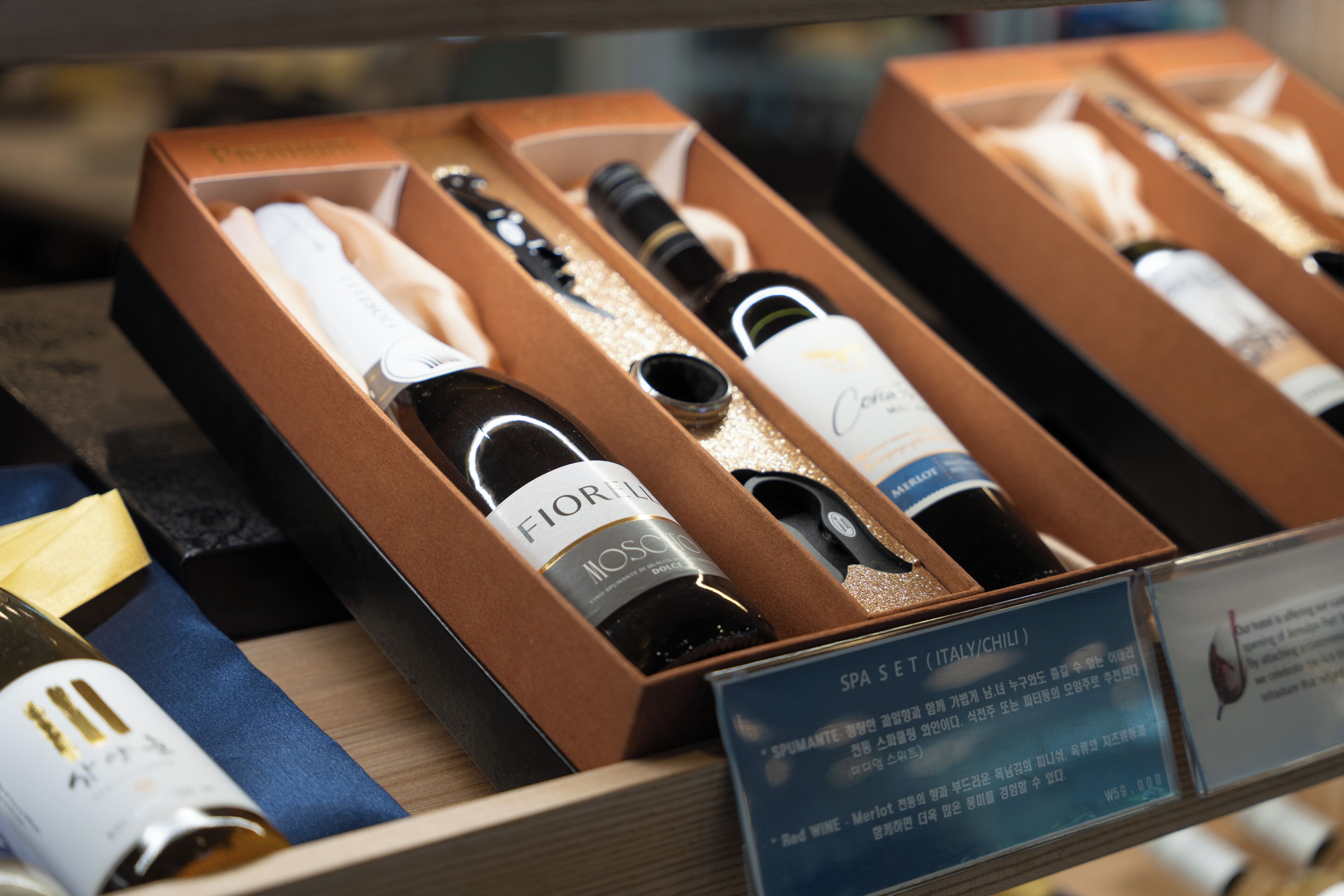 A display of wine bottles in wooden boxes with labels, some of which are labeled as "Fiorino" and "Spa S E (Italy/Chili)".