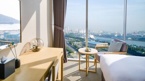 A hotel room with a large window, a bed, a desk, and a chair. - Harbor Park Hotel (Incheon)