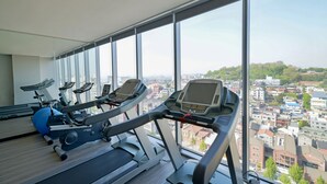 A gym with treadmills and exercise balls, large windows with a city view. - Harbor Park Hotel (Incheon)