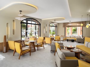 A spacious lounge area with multiple seating options, large windows, and a modern ceiling design. - Labranda Targa Club Aqua Parc (Marrakech)