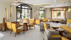 A modern lounge area with yellow and grey seating, large windows, and a curved ceiling design. - Aqualis Club Resort Marrakech (Marrakech)