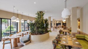 A modern dining area with round tables, chairs, and hanging pendant lights. - Aqualis Club Resort Marrakech (Marrakech)