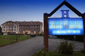 A hotel sign with the name "Hotel Comillas" and a large 'H' above it. - Hotel Comillas (Comillas)