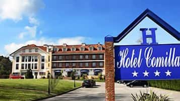 Hotel Comilla's classic entrance welcomes guests with a prominent sign and beautiful surroundings.