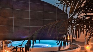 Uma área de spa moderna, com piscina aquecida, rodeada por plantas decorativas e velas.