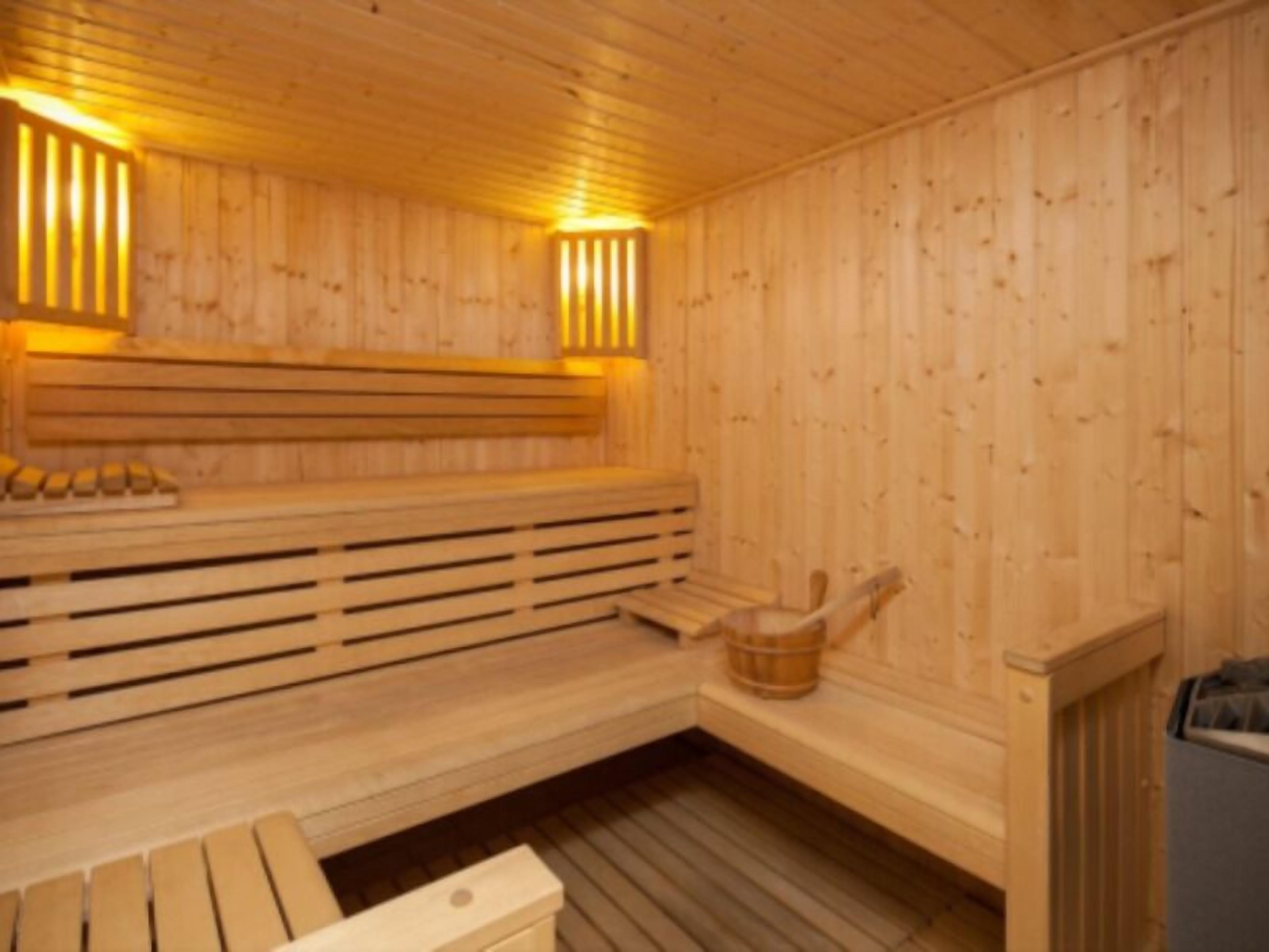 Una sauna de madera con bancos y un asiento de banco.