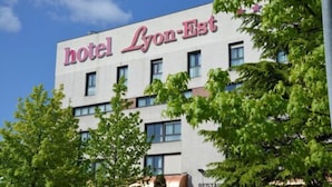 A hotel named 'hotel Lyon-Est' with a modern facade and multiple windows. - Logis Lyon Est (Saint-Maurice-de-Beynost)