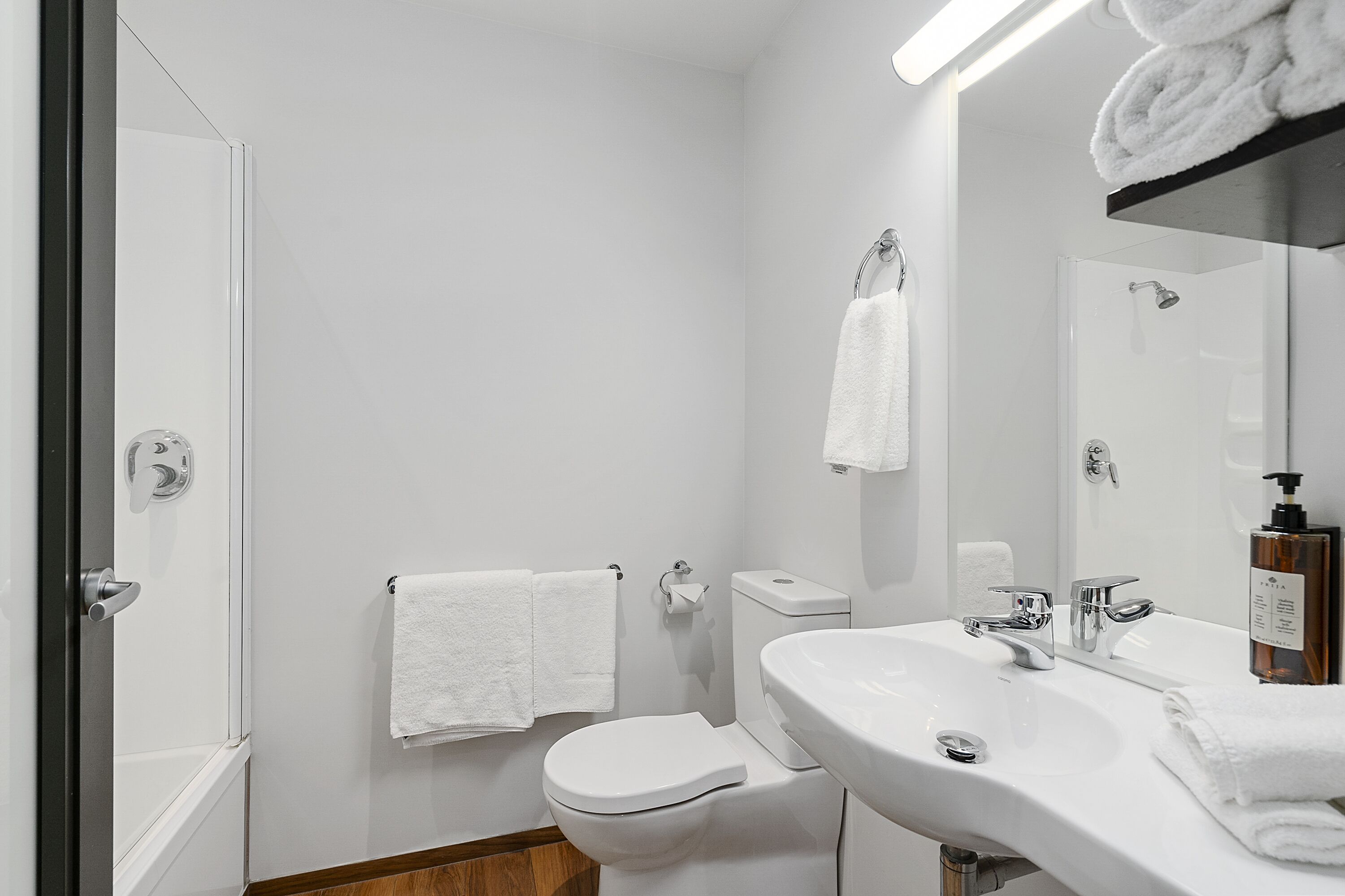 Un baño moderno con inodoro, lavamanos y ducha.