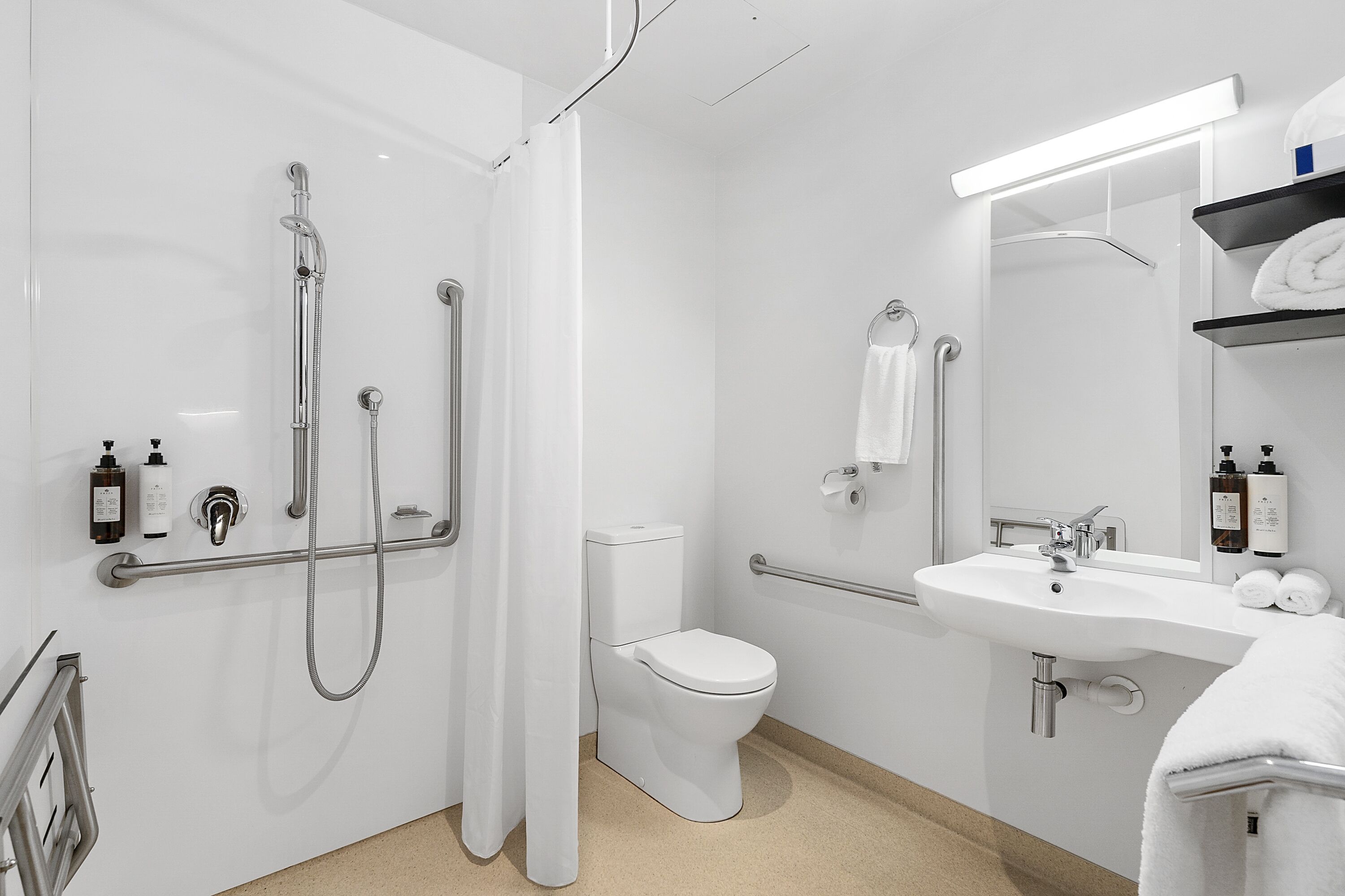A modern bathroom with a shower, toilet, and sink.