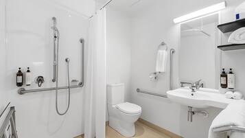 A modern bathroom with a shower, toilet, and sink.