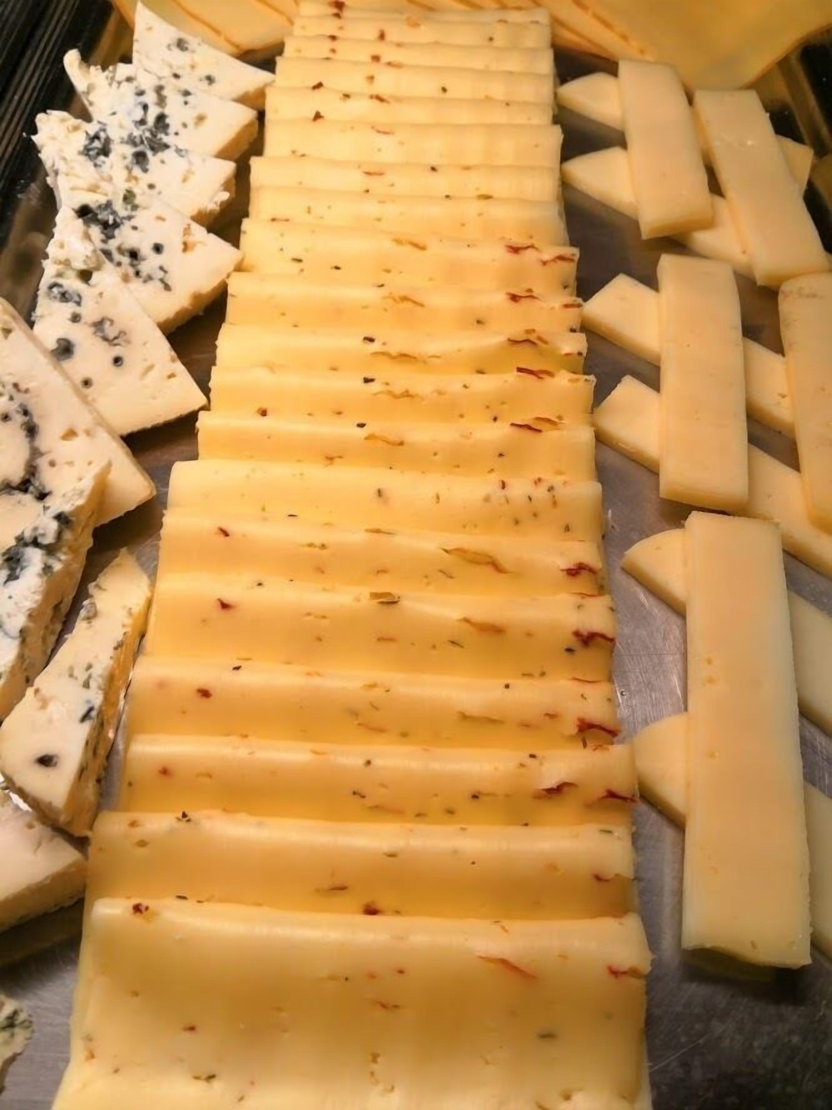 A cheese board with various types of cheese, including blue cheese and cheddar.