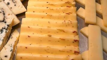 A cheese board with various types of cheese, including blue cheese and cheddar.