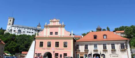 A pink building with a sign reading "Hotel Restevace U Martina" and a red car parked in front.