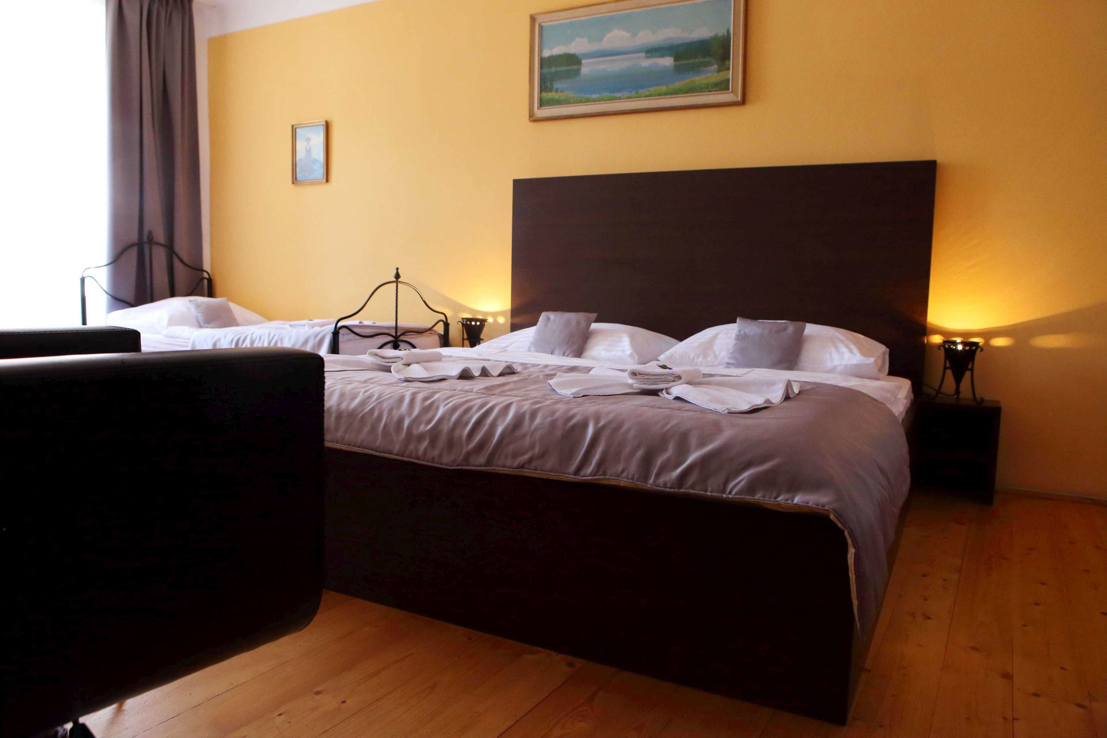 A hotel room with a large bed, two bedside tables, a chair, and a painting on the wall.