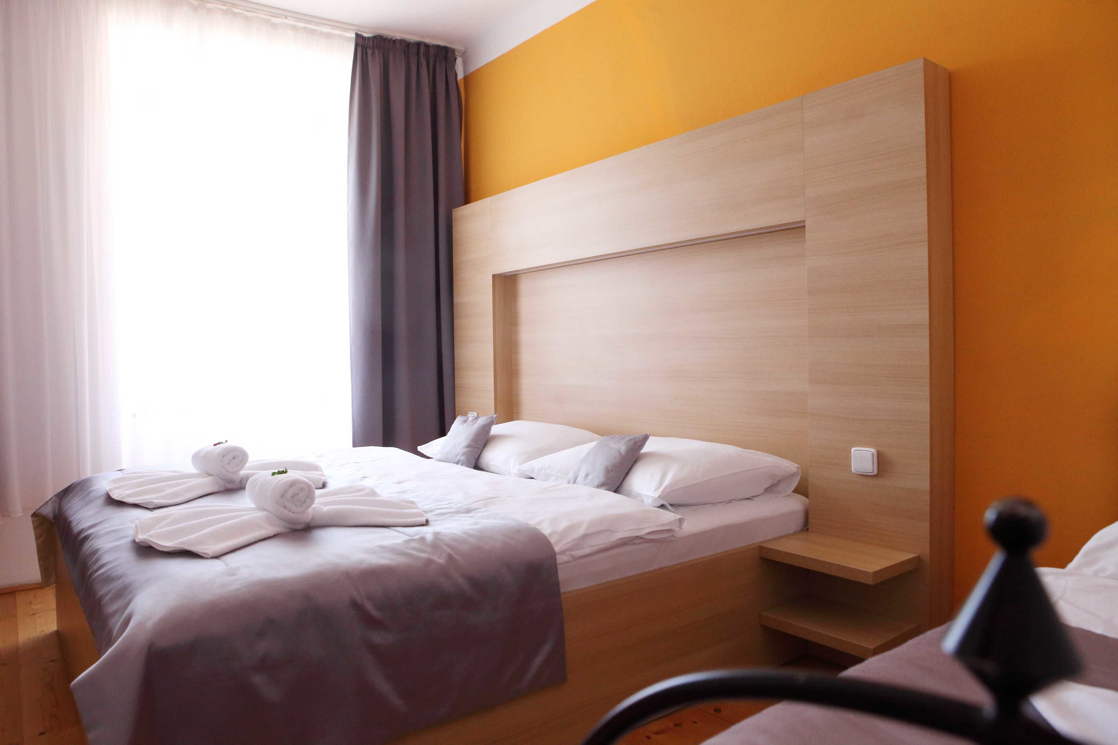 A hotel room with a bed, a bedside table, and a headboard.