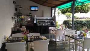 Een restaurant met terras, een toonbank met etalage en een televisie aan de muur.