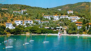 A coastal town with white buildings, a clear blue sea, and sailboats. - Leda Village Resort (South Pelion)