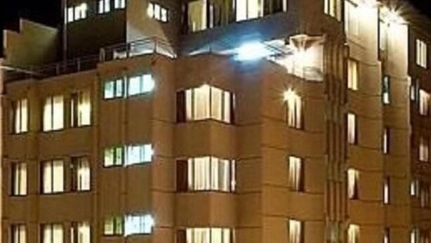 Un edificio de varios pisos con numerosas ventanas, probablemente un hotel o un conjunto de apartamentos.