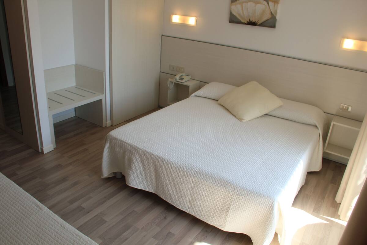 Une chambre à coucher avec un lit, des tables de chevet et une commode.