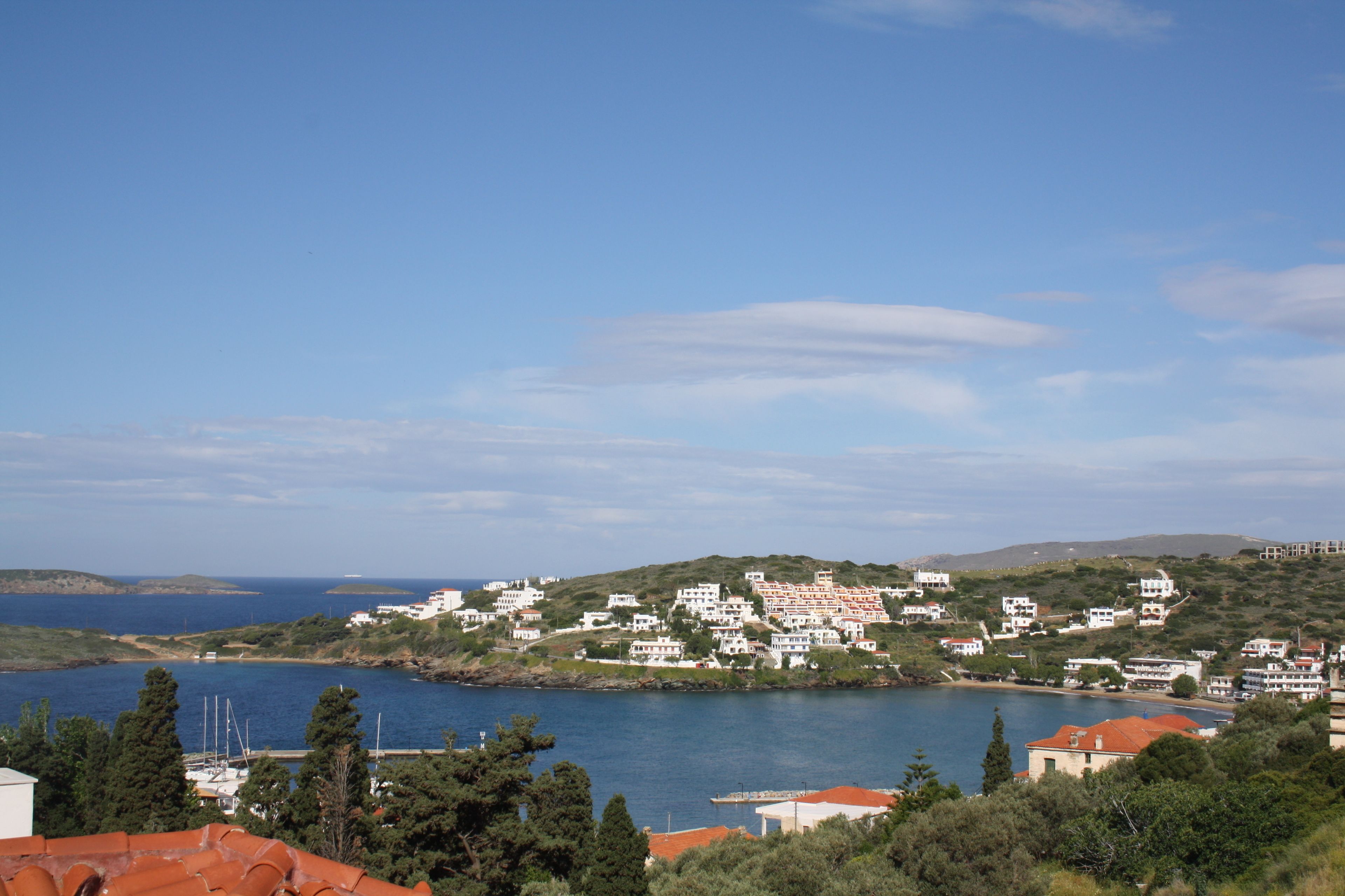 A coastal town with white buildings, a clear blue sky, and a body of water.