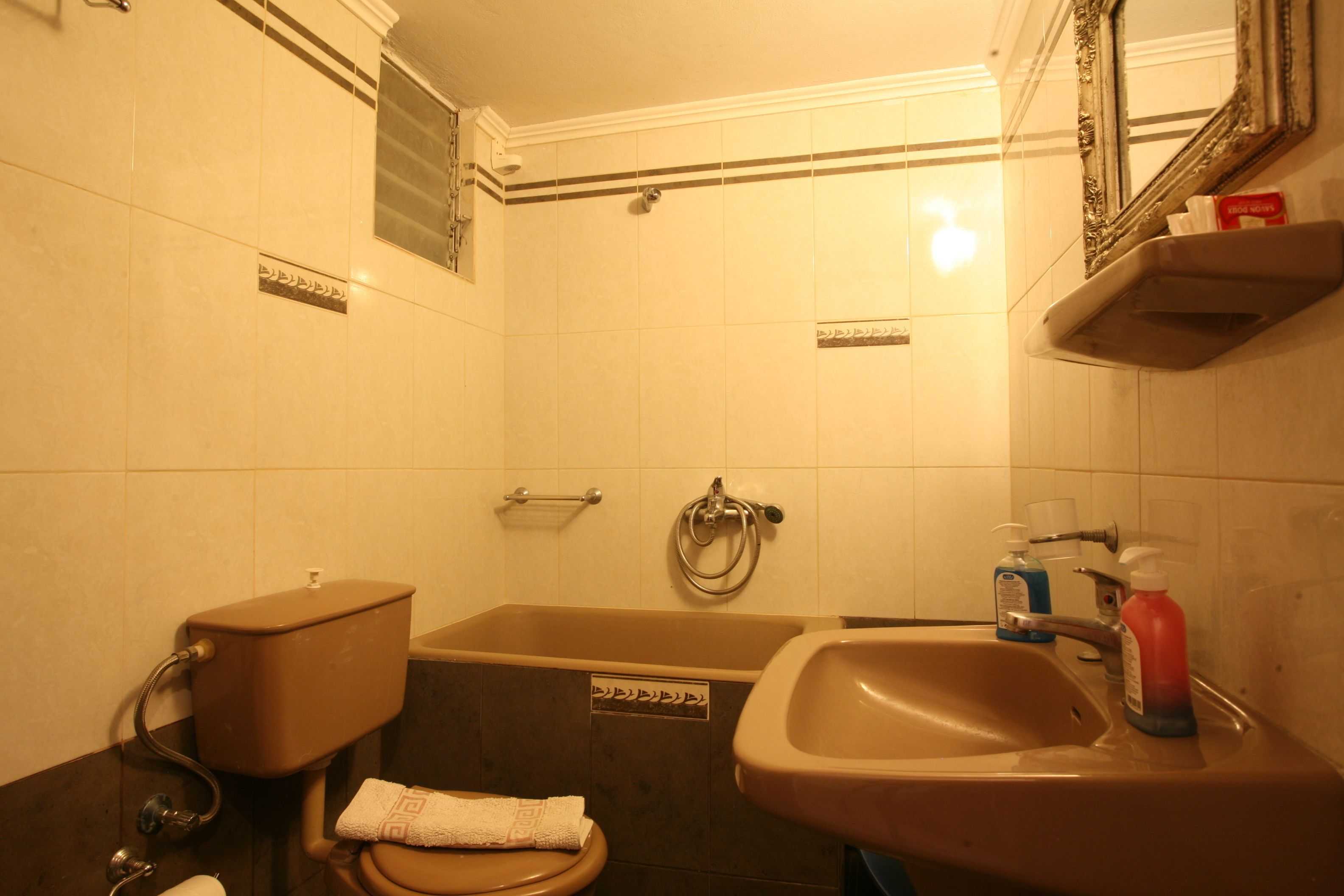 A bathroom with a toilet, bathtub, sink, and a mirror.