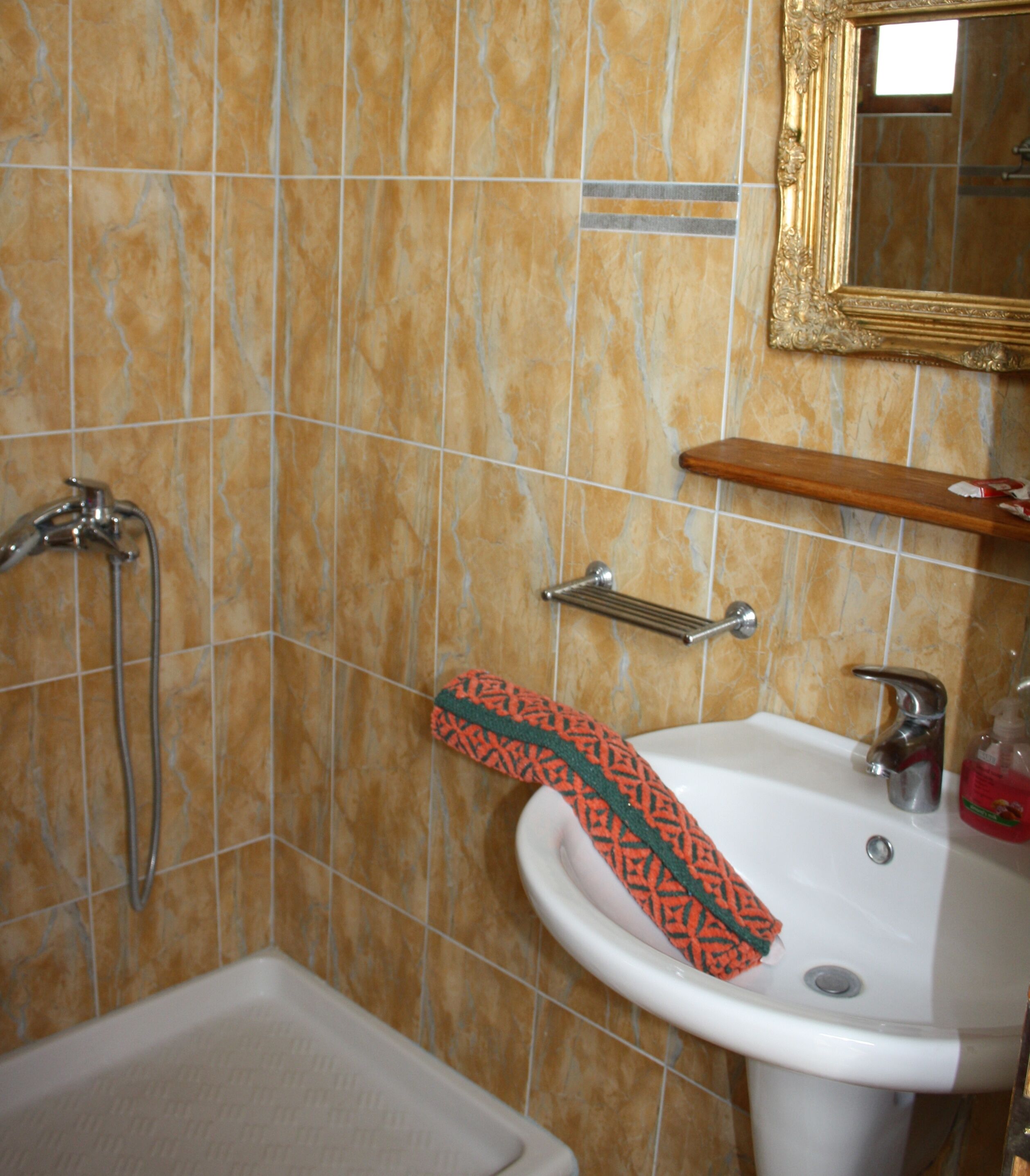 A bathroom with a white sink, a towel rack, and a shower.