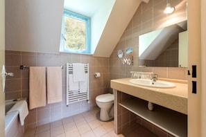 A modern bathroom with a skylight, a bathtub, a toilet, and a sink. - Hôtel Ardiden (Luz-Saint-Sauveur)